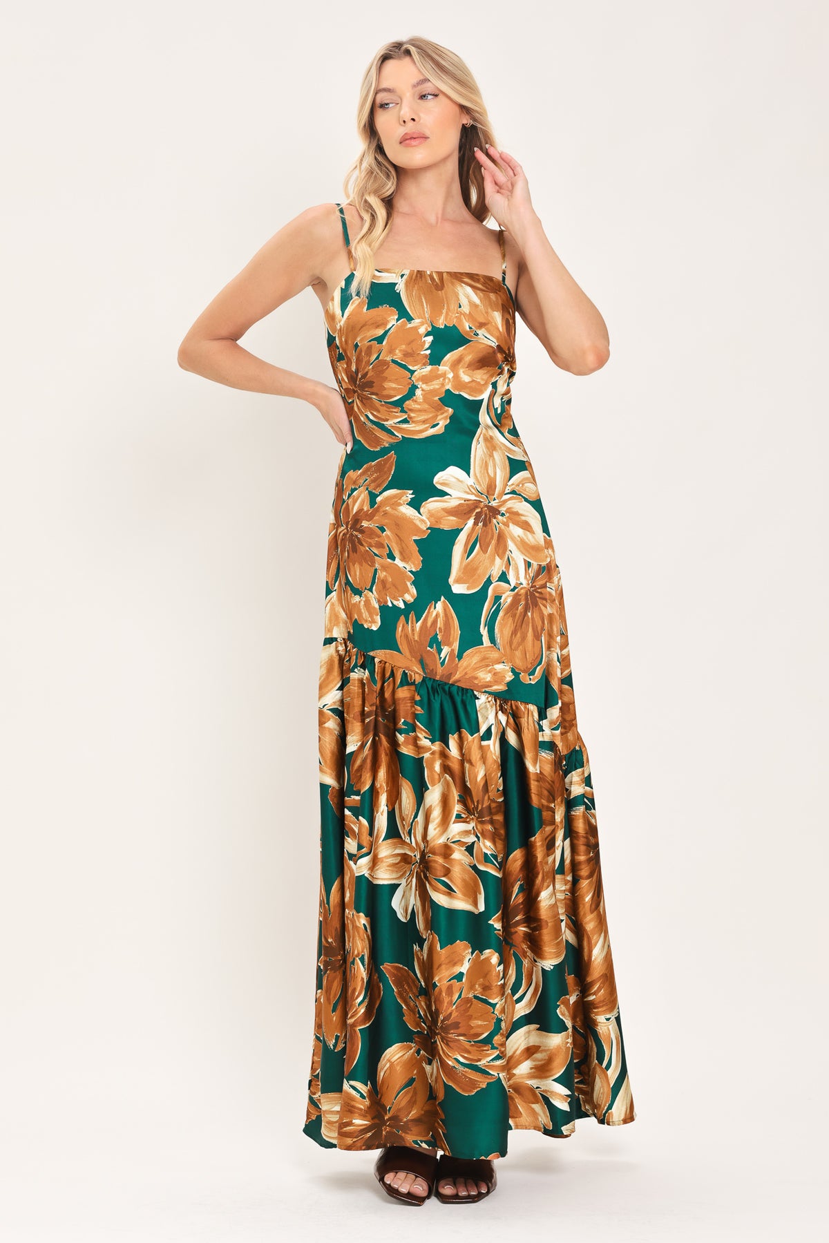 Woman wearing a spaghetti strap green maxi dress with brown floral pattern printed and asymmetrical tier from the thigh down | Flying Tomato