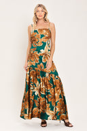 Woman wearing a spaghetti strap green maxi dress with brown floral pattern printed and asymmetrical tier from the thigh down | Flying Tomato