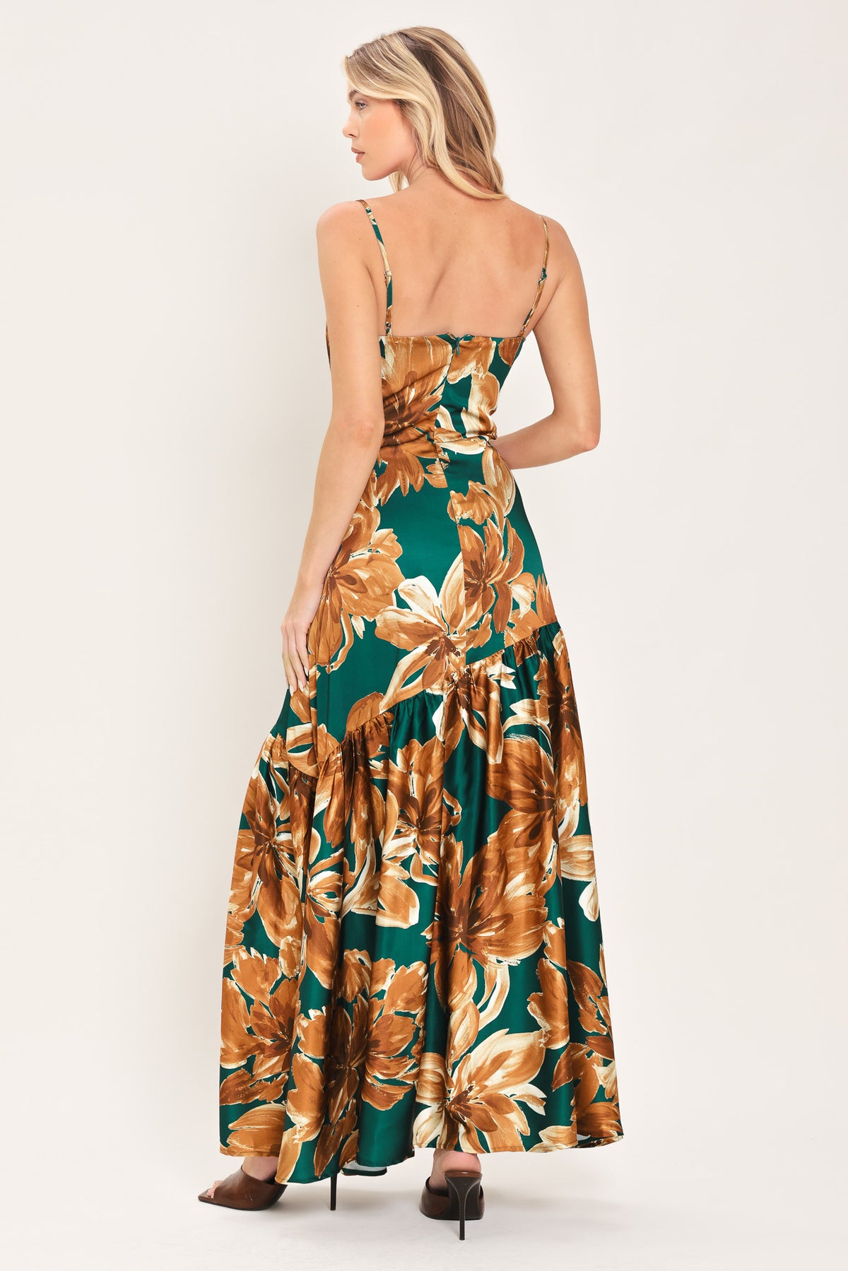 Woman wearing a spaghetti strap green maxi dress with brown floral pattern printed and asymmetrical tier from the thigh down | Flying Tomato