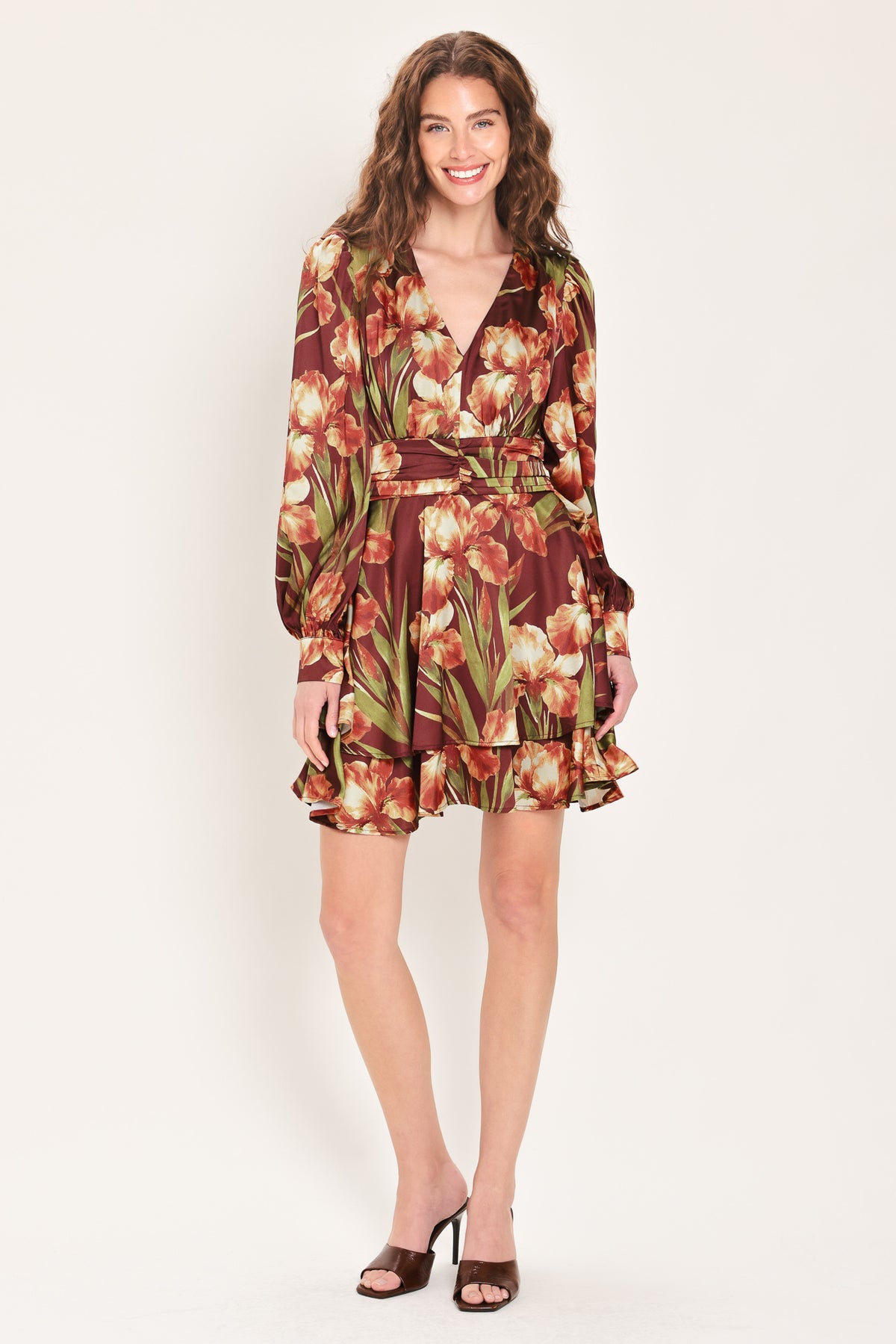 Woman wearing a burgundy long sleeve mini dress with a v neckline and ruched waist and floral and leaf print | Flying Tomato 