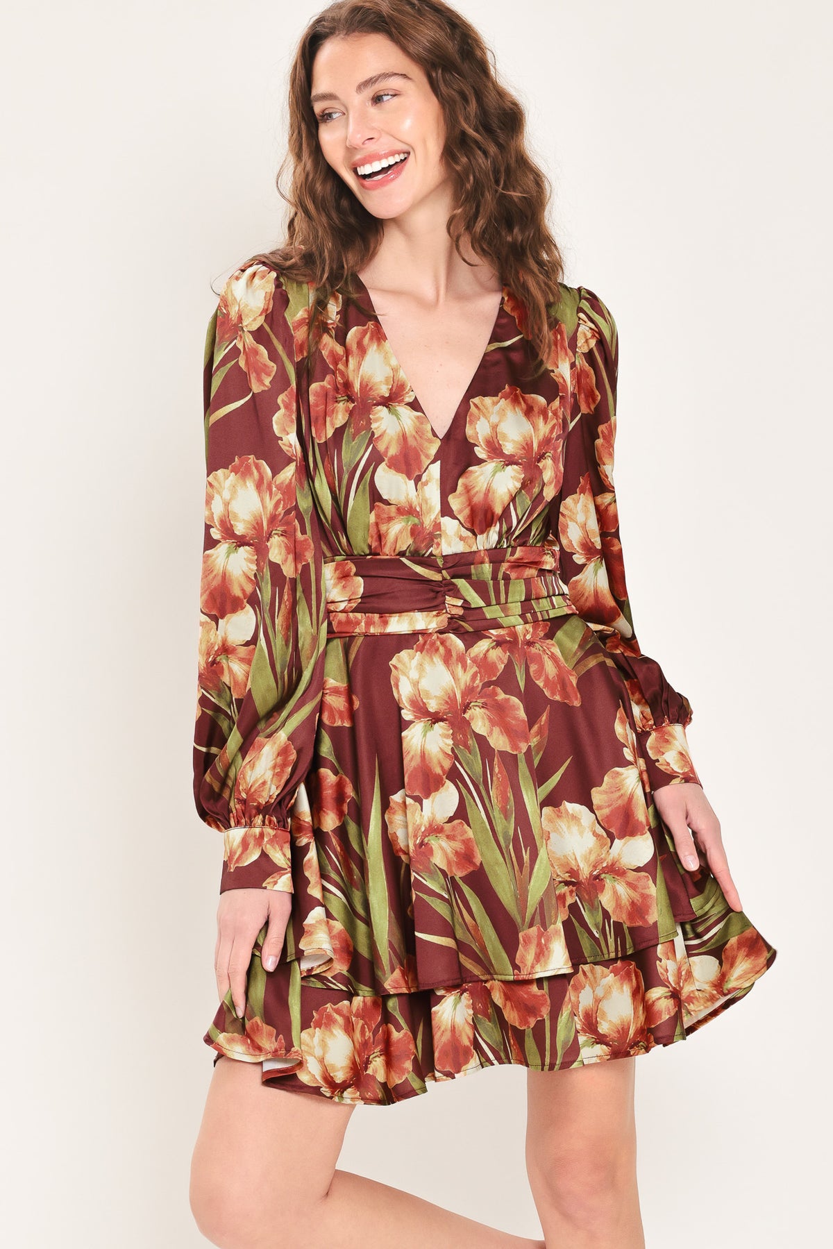 Woman wearing a burgundy long sleeve mini dress with a v neckline and ruched waist and floral and leaf print | Flying Tomato 
