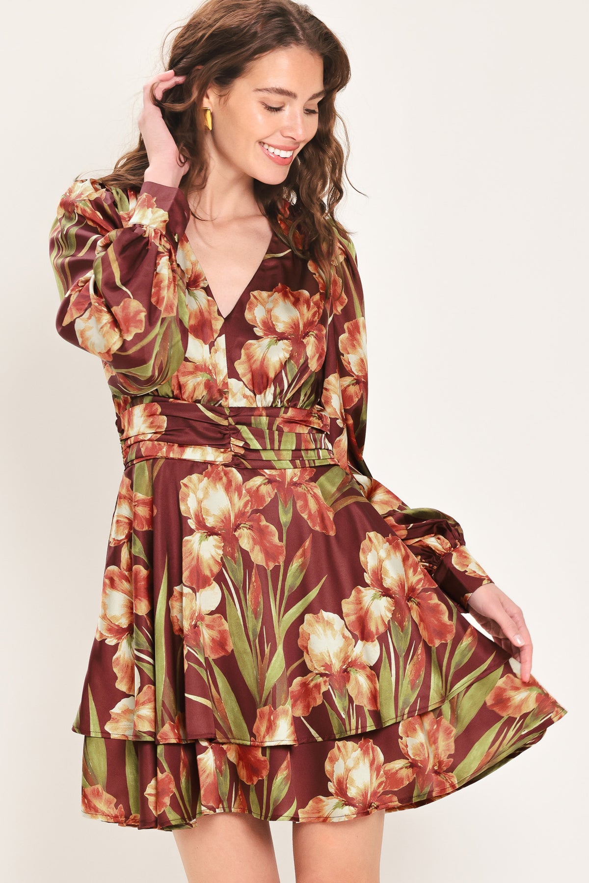 Woman wearing a burgundy long sleeve mini dress with a v neckline and ruched waist and floral and leaf print | Flying Tomato 