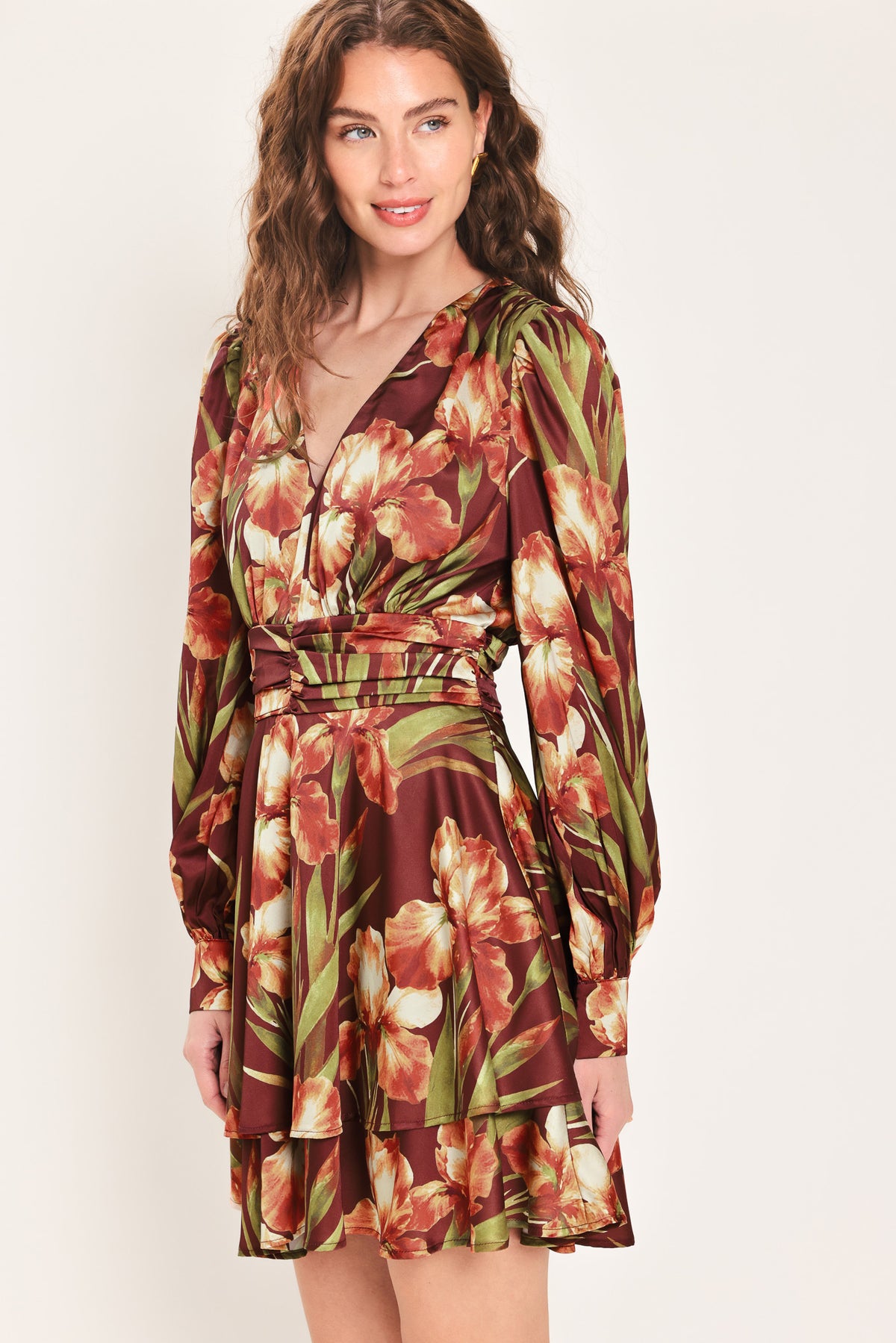 Woman wearing a burgundy long sleeve mini dress with a v neckline and ruched waist and floral and leaf print | Flying Tomato 