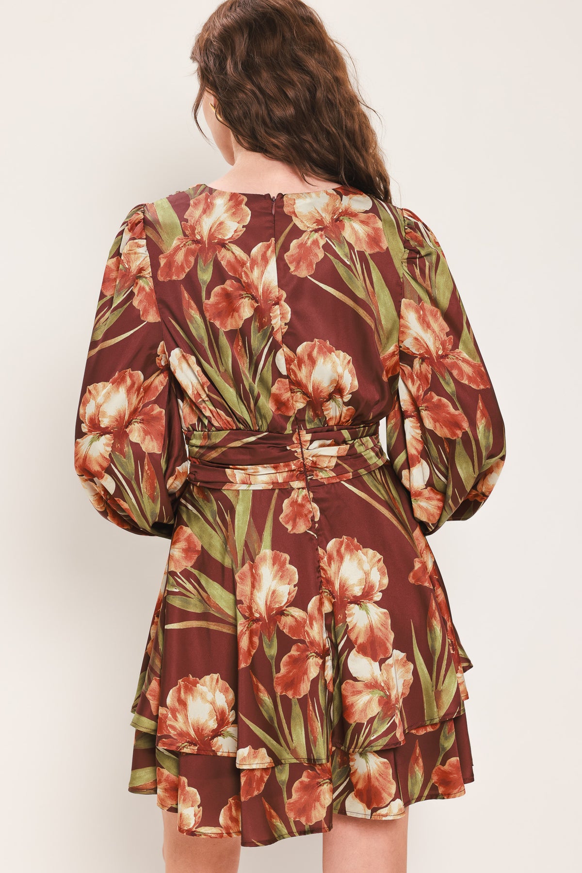 Woman wearing a burgundy long sleeve mini dress with a v neckline and ruched waist and floral and leaf print | Flying Tomato 