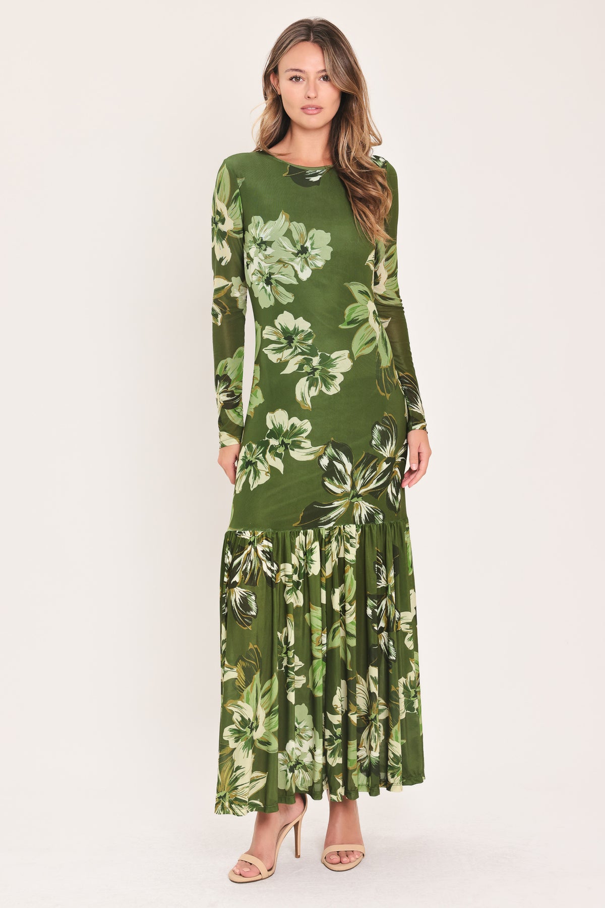 A woman modeling a long-sleeve power mesh maxi dress with a moss green and white tropical floral print | Flying Tomato