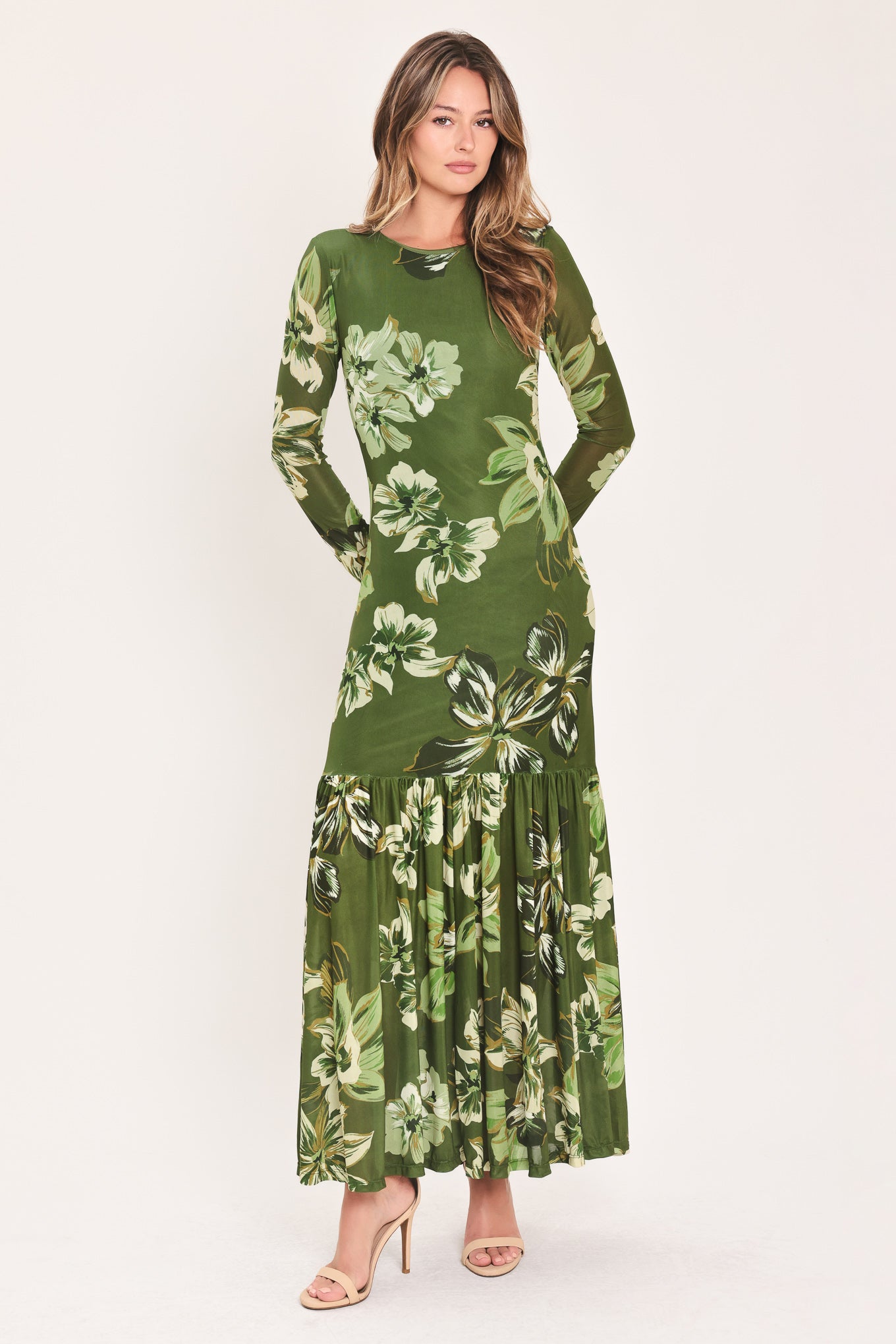 A woman modeling a long-sleeve power mesh maxi dress with a moss green and white tropical floral print | Flying Tomato