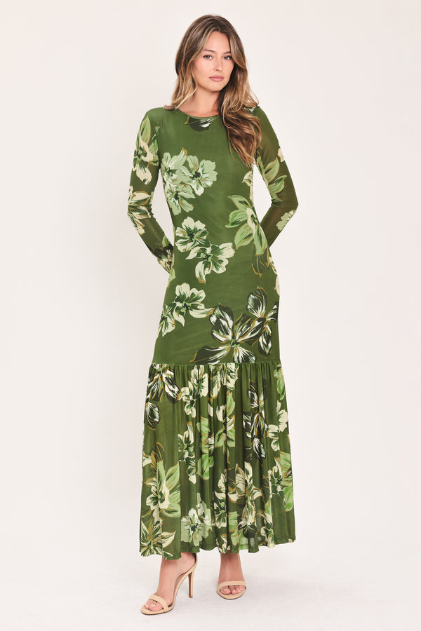 A woman modeling a long-sleeve power mesh maxi dress with a moss green and white tropical floral print | Flying Tomato