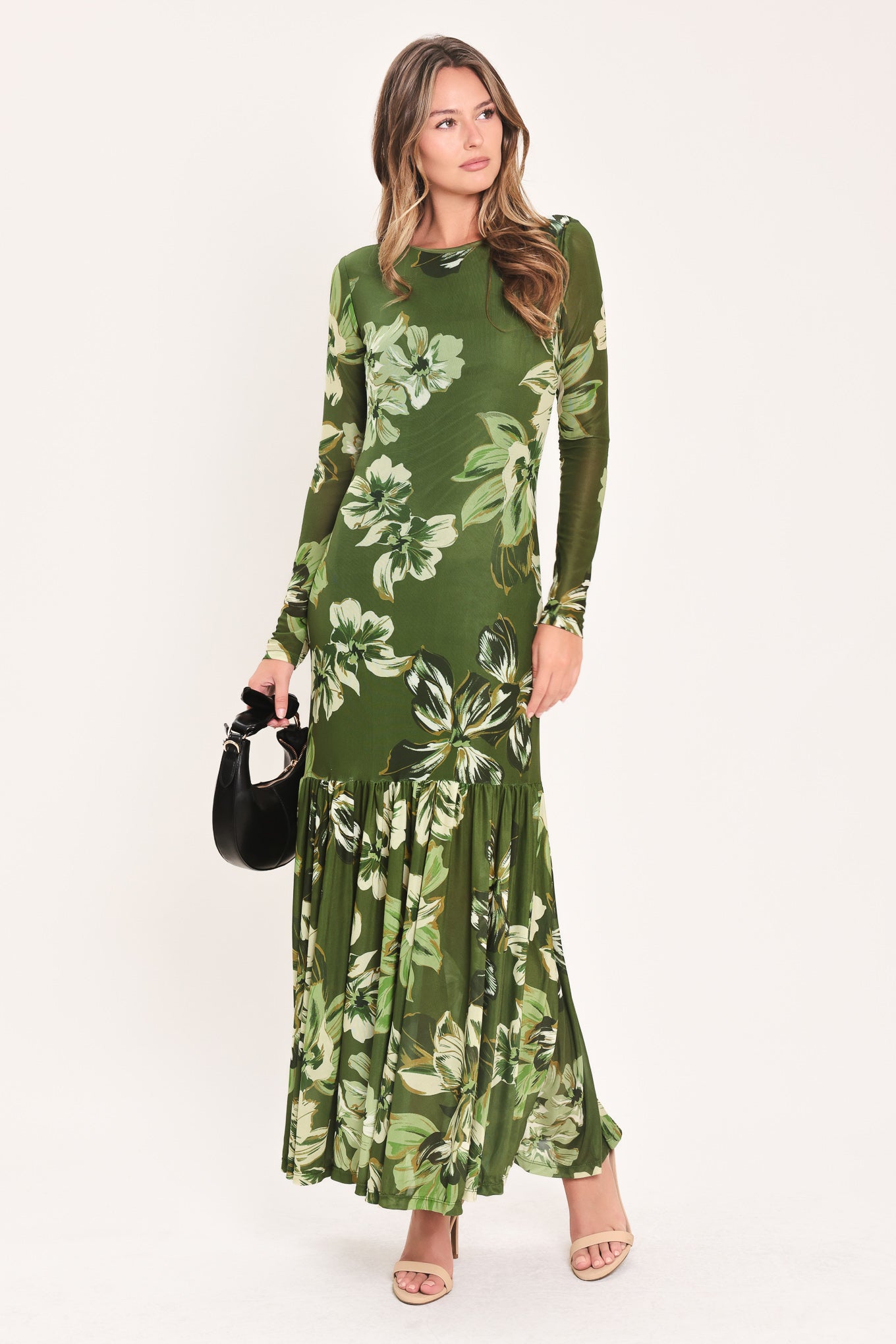 A woman modeling a long-sleeve power mesh maxi dress with a moss green and white tropical floral print | Flying Tomato