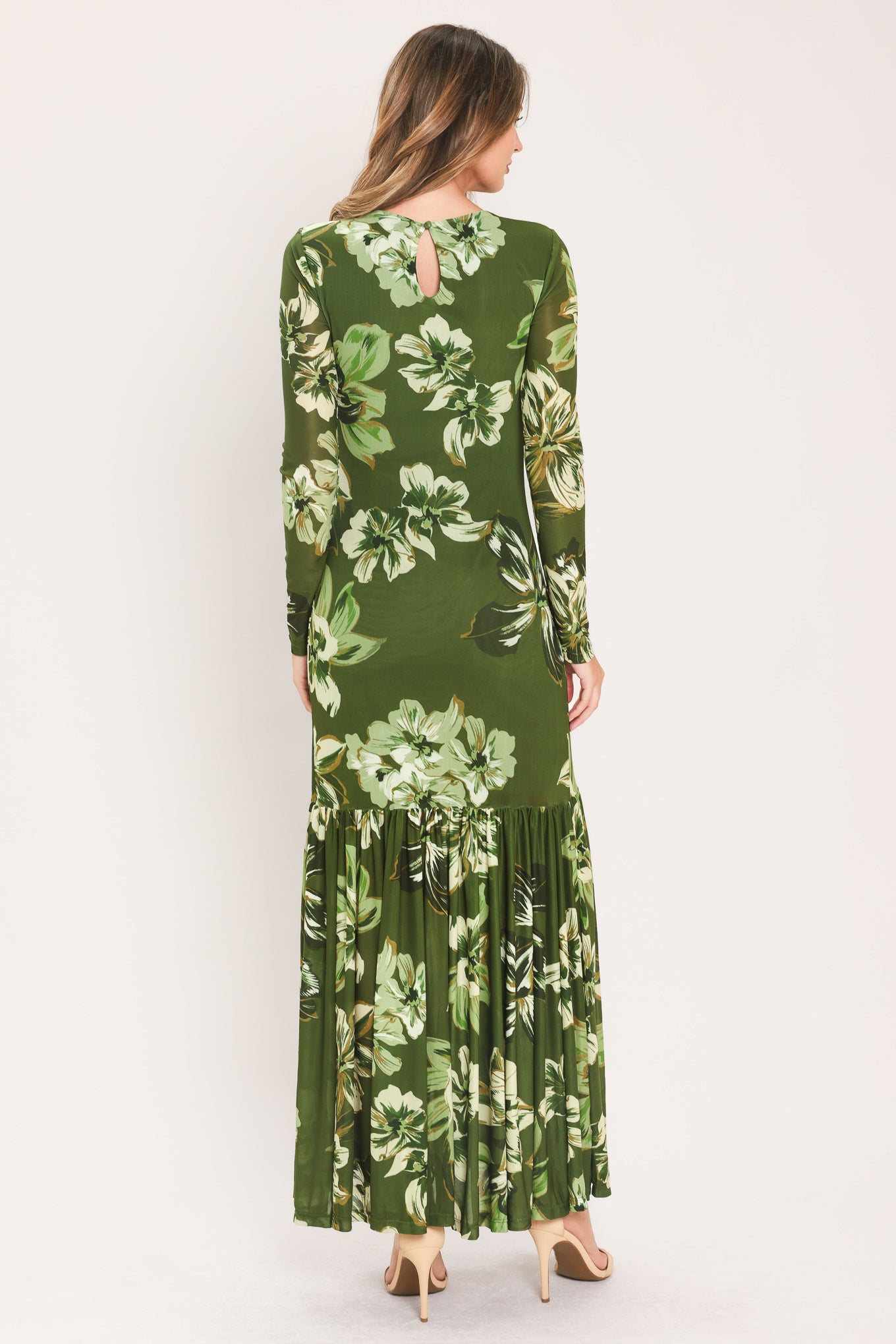 A woman modeling a long-sleeve power mesh maxi dress with a moss green and white tropical floral print | Flying Tomato