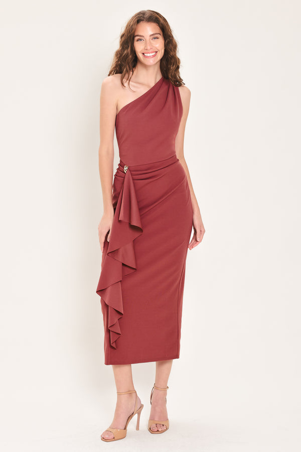 Woman wearing a burnt sienna colored one-shoulder midi dress with a single ruffle draping from the waistline to the end of the dress and hardware piece at the waist | Flying Tomato