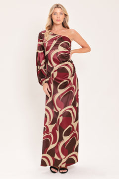 A woman modeling a one-shoulder maxi dress with a bold abstract swirl pattern in burgundy, brown, and beige | Flying Tomato