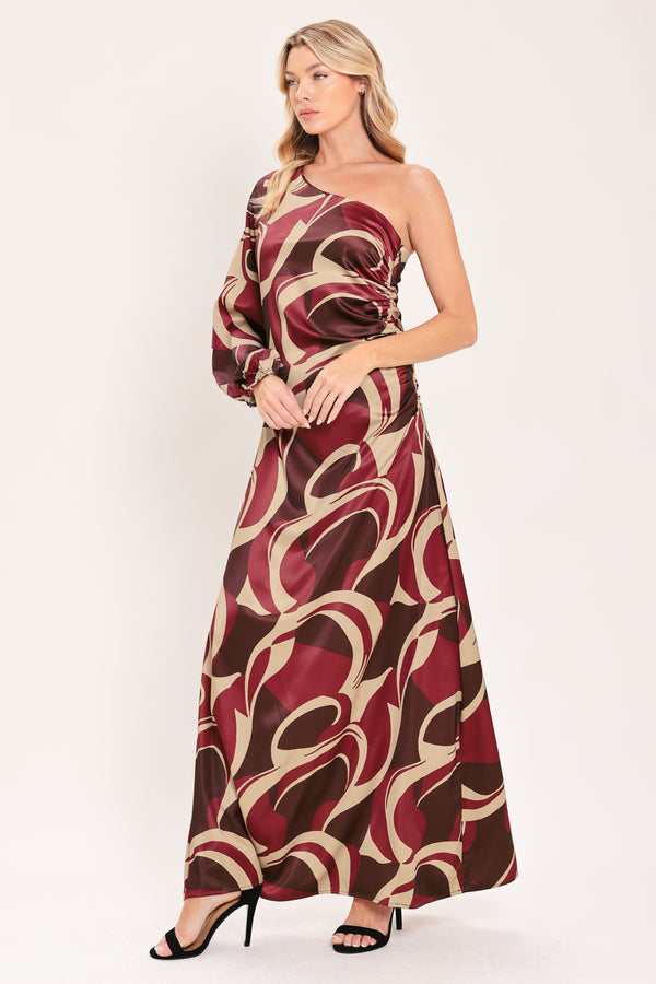 A woman modeling a one-shoulder maxi dress with a bold abstract swirl pattern in burgundy, brown, and beige | Flying Tomato
