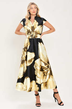 Woman wearing a black short sleeve midi dress with big gold/beige floral print, v-neck, matching waist belt, and pockets | Flying Tomato