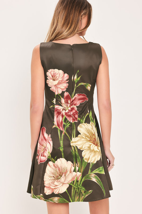 Woman wearing a sleeveless dark brown mini dress with a beige, pink, and burgundy floral print | Flying Tomato