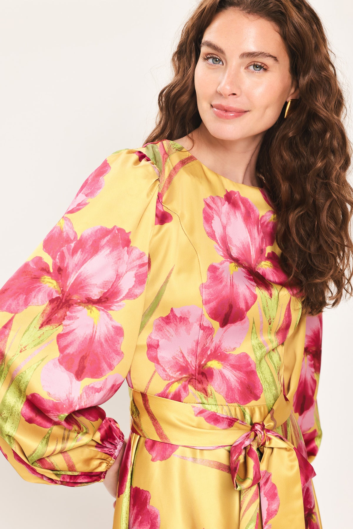 Woman wearing a long sleeve golden yellow midi dress with pink florals printed and self tie waist belt | Flying Tomato
