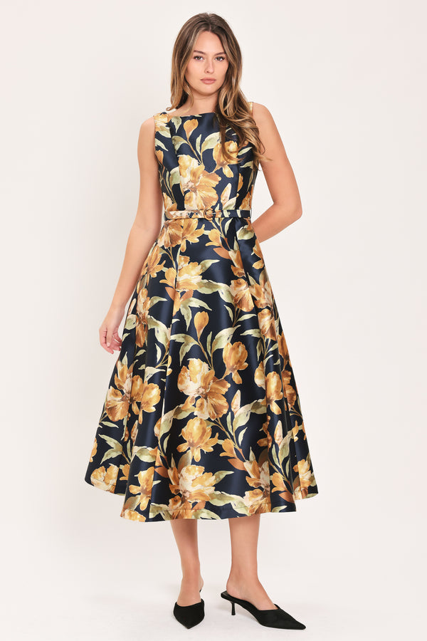 A woman modeling a sleeveless A-line midi dress with a dark navy blue background and a large yellow and gold floral print, featuring a matching fabric tie belt at the waist | Flying Tomato