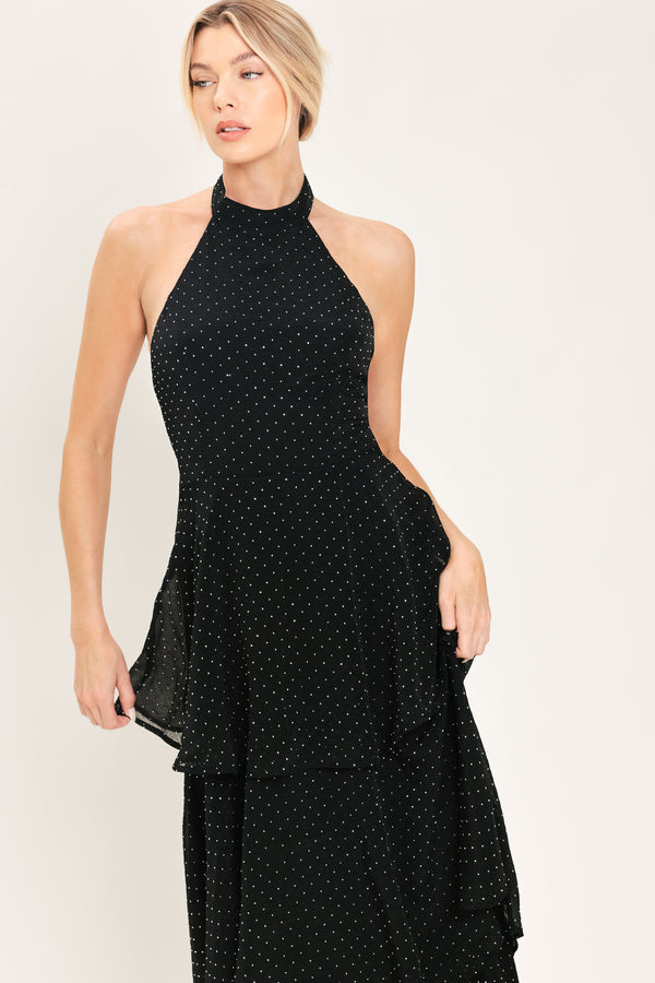 Woman wearing a sleeveless halter black maxi dress with small rhinestones and tiered skirt | Flying Tomato