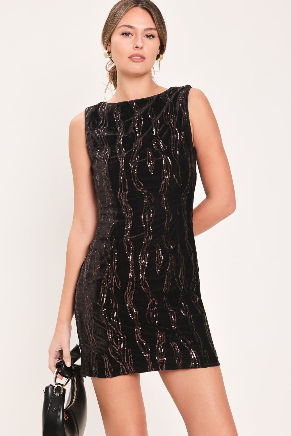 Woman wearing a sleeveless dark brown velvet mini dress with a squiggly vertical sequins line pattern | Flying Tomato