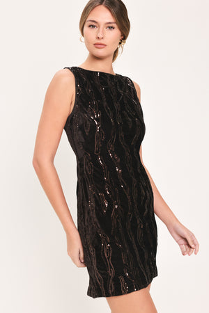 Woman wearing a sleeveless dark brown velvet mini dress with a squiggly vertical sequins line pattern | Flying Tomato