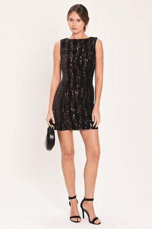 Woman wearing a sleeveless dark brown velvet mini dress with a squiggly vertical sequins line pattern | Flying Tomato