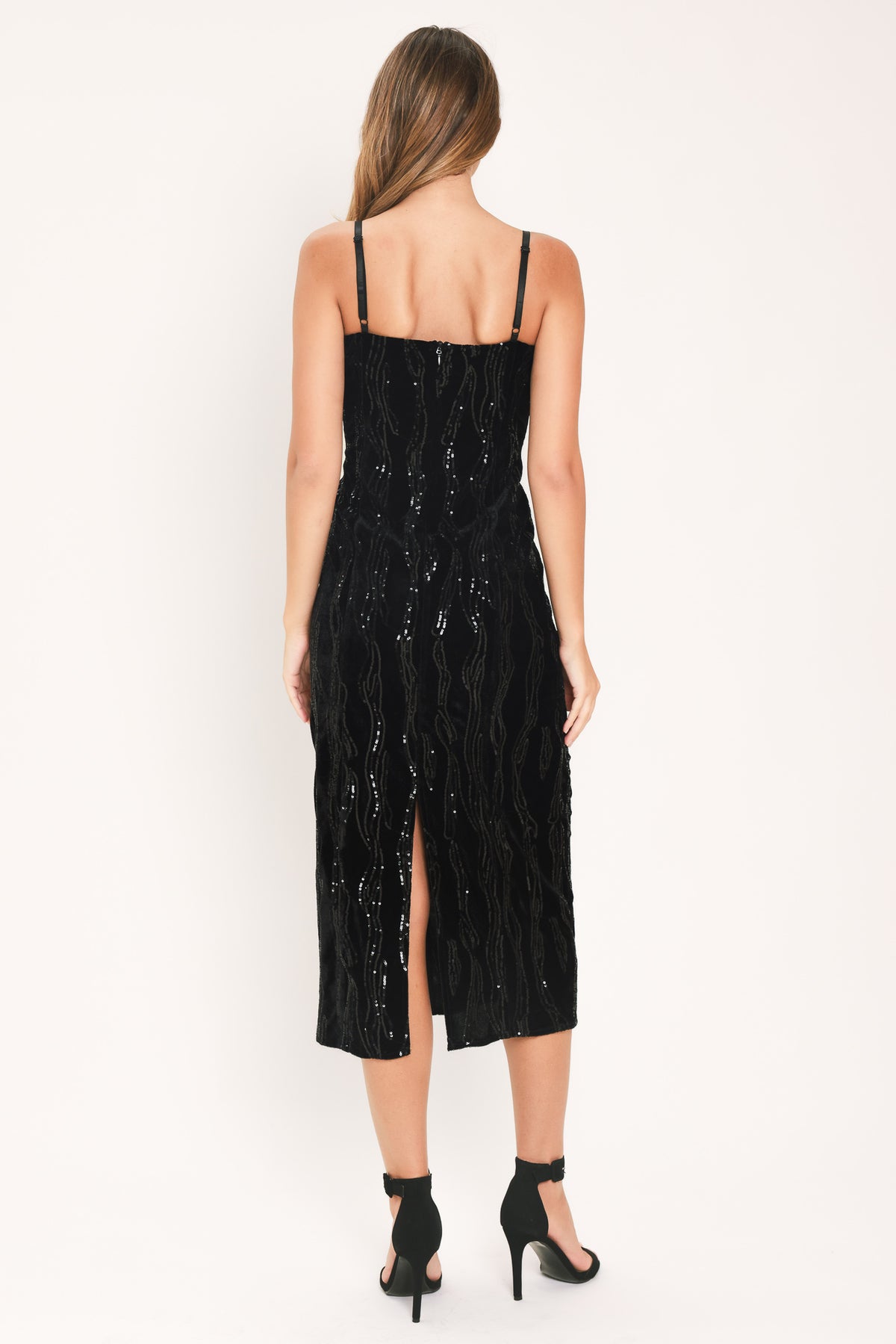 A woman modeling a black sequined midi dress with spaghetti straps and a black lace sweetheart neckline | Flying Tomato