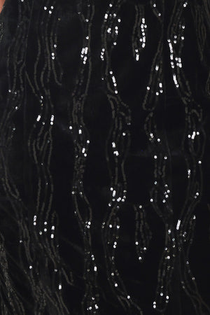 A woman modeling a black sequined midi dress with spaghetti straps and a black lace sweetheart neckline | Flying Tomato