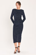 Woman wearing a long sleeve navy blue velvet midi dress with a fish scale pattern outlined with embellishments | Flying Tomato