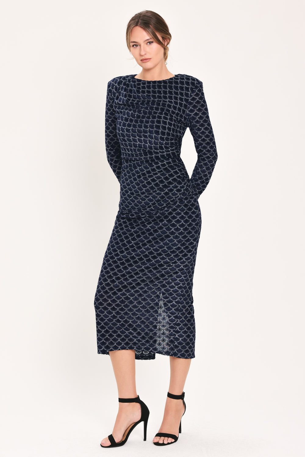 Woman wearing a long sleeve navy blue velvet midi dress with a fish scale pattern outlined with embellishments | Flying Tomato