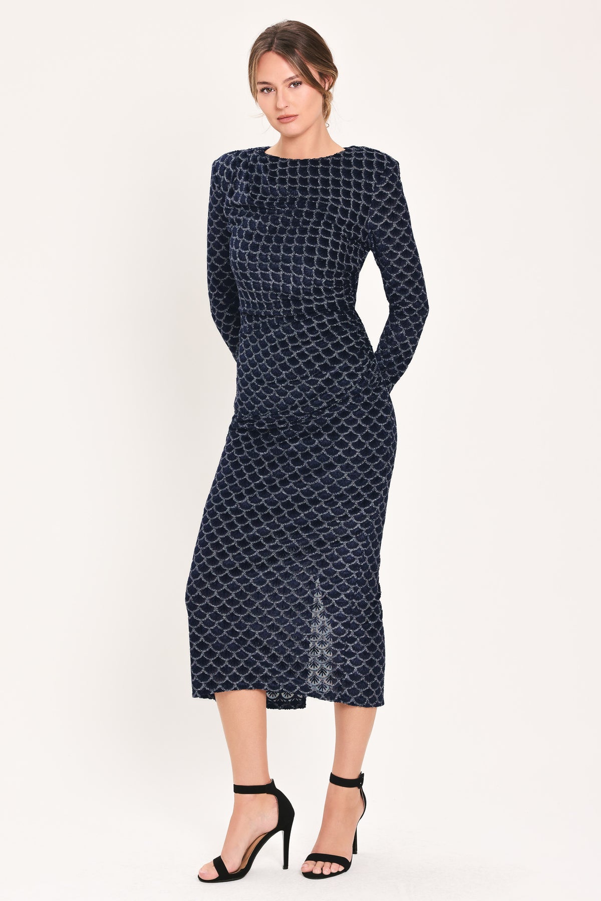 Woman wearing a long sleeve navy blue velvet midi dress with a fish scale pattern outlined with embellishments | Flying Tomato