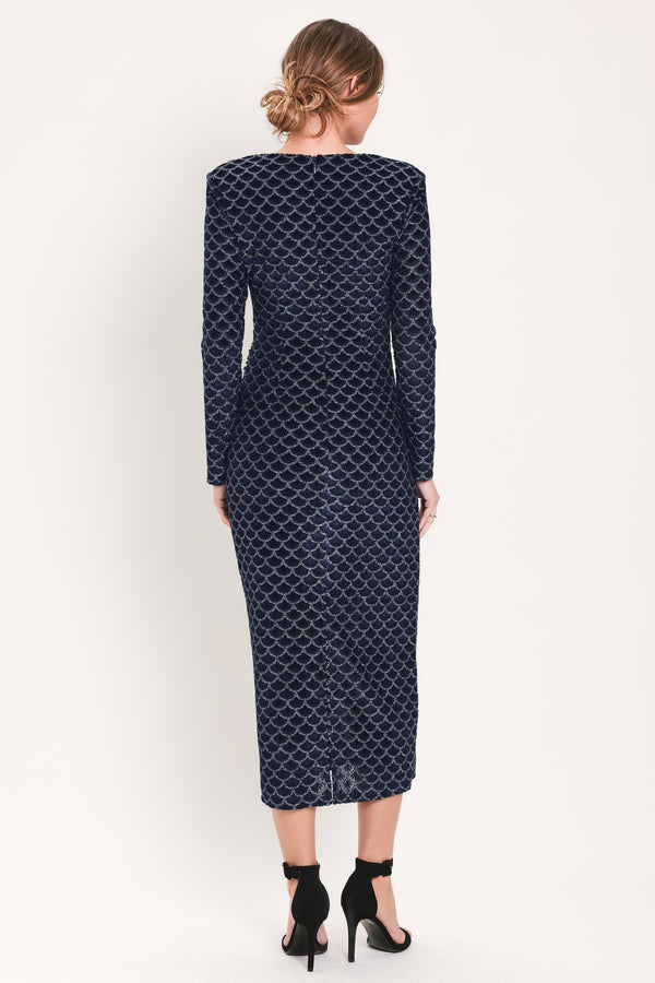 Woman wearing a long sleeve navy blue velvet midi dress with a fish scale pattern outlined with embellishments | Flying Tomato