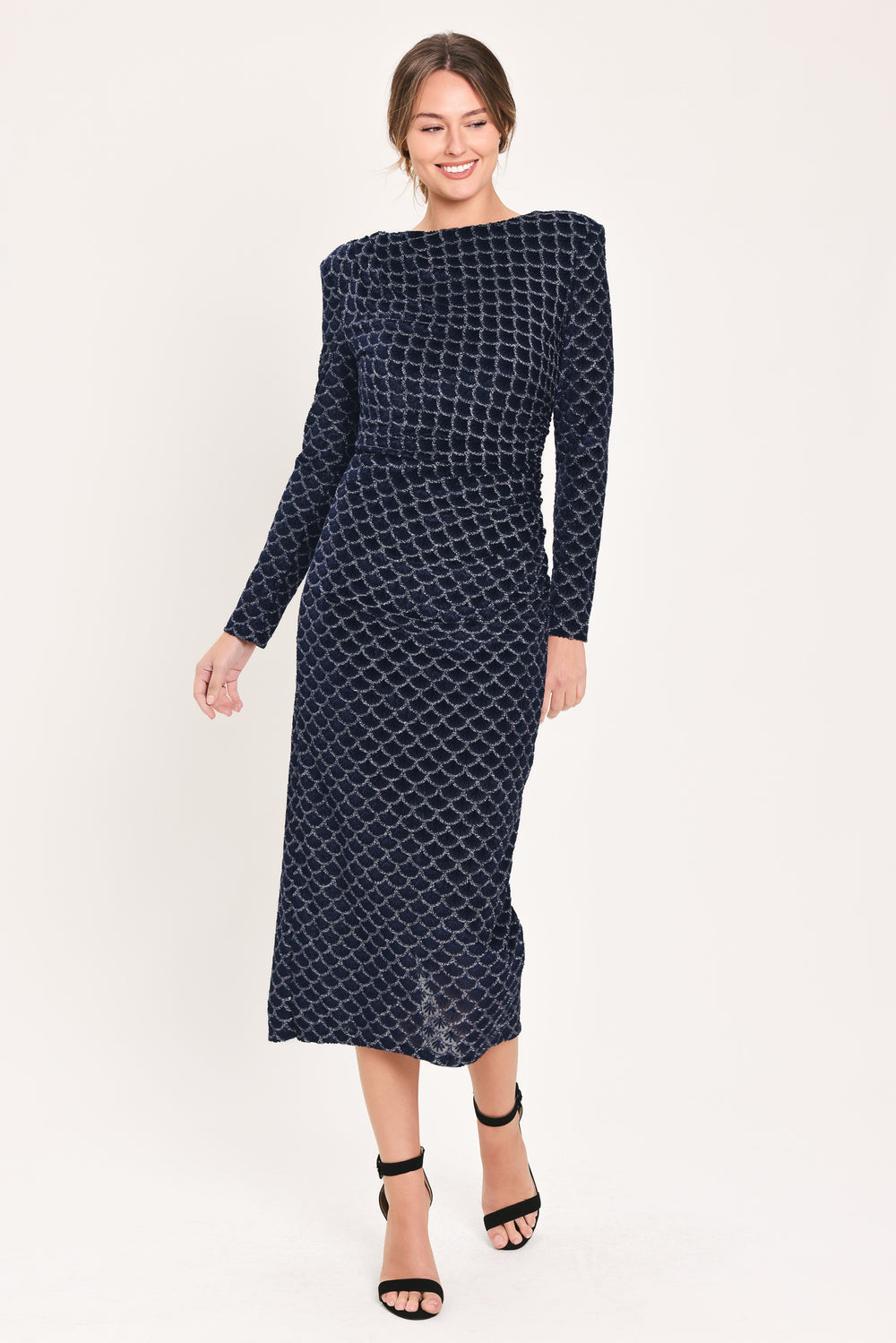 Woman wearing a long sleeve navy blue velvet midi dress with a fish scale pattern outlined with embellishments | Flying Tomato