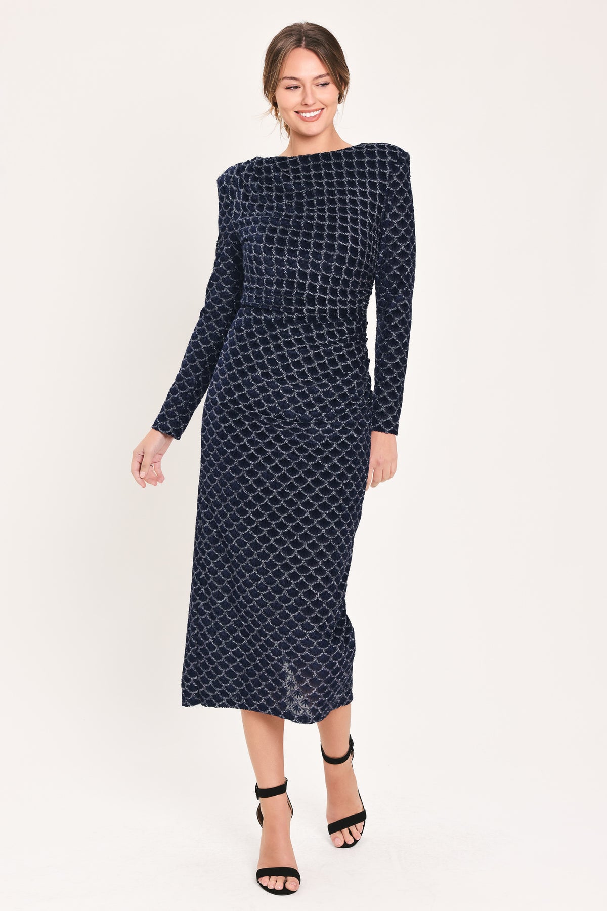 Woman wearing a long sleeve navy blue velvet midi dress with a fish scale pattern outlined with embellishments | Flying Tomato