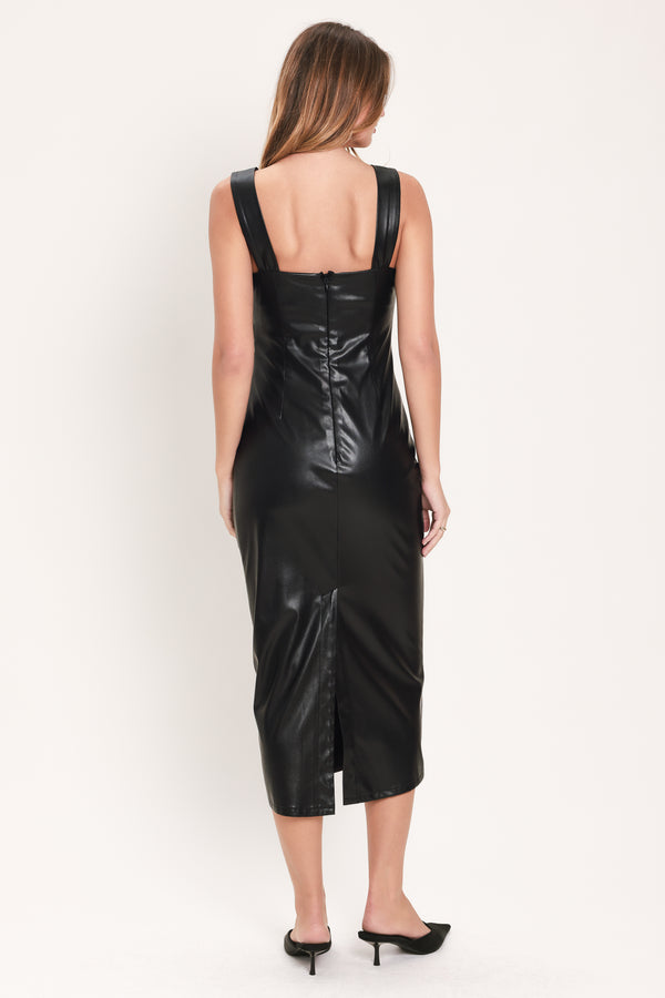 Woman wearing a sleeveless square neckline black faux leather midi dress with side ruching and gold hardware where the straps meet the neckline | Flying Tomato