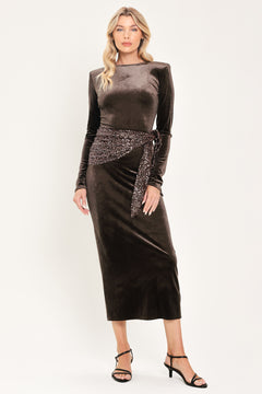 A woman modeling a long-sleeve, round-neck midi dress in dark brown velvet with a matching sequined sash belt at the waist | Flying Tomato