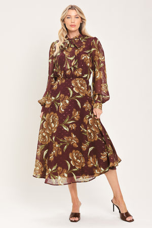A woman modeling a long-sleeve burgundy midi dress with a brown and gold floral print, featuring a high neck, ruffled collar, and a self-tie belt at the waist | Flying Tomato