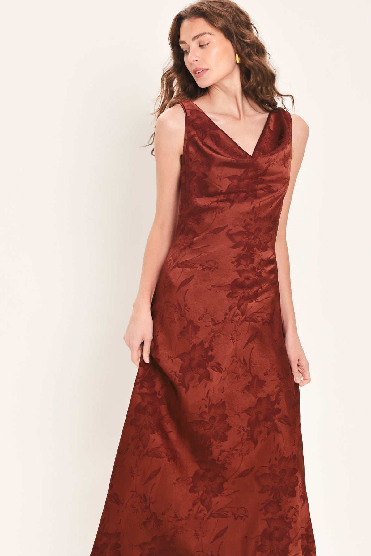 Woman wearing a sleeveless brick red satin jacquard midi dress with a cowl neckline and u-back | Flying Tomato