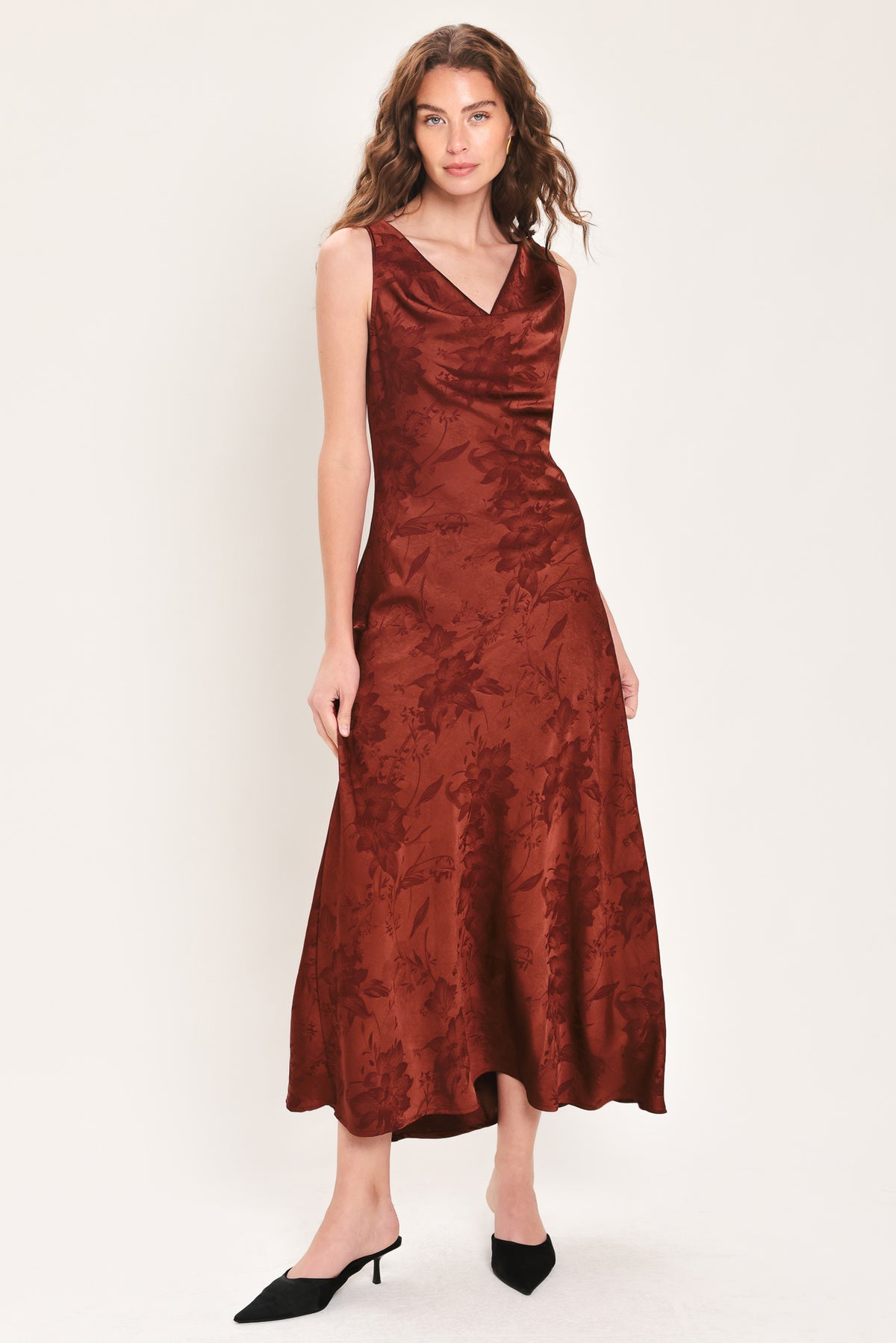 Woman wearing a sleeveless brick red satin jacquard midi dress with a cowl neckline and u-back | Flying Tomato