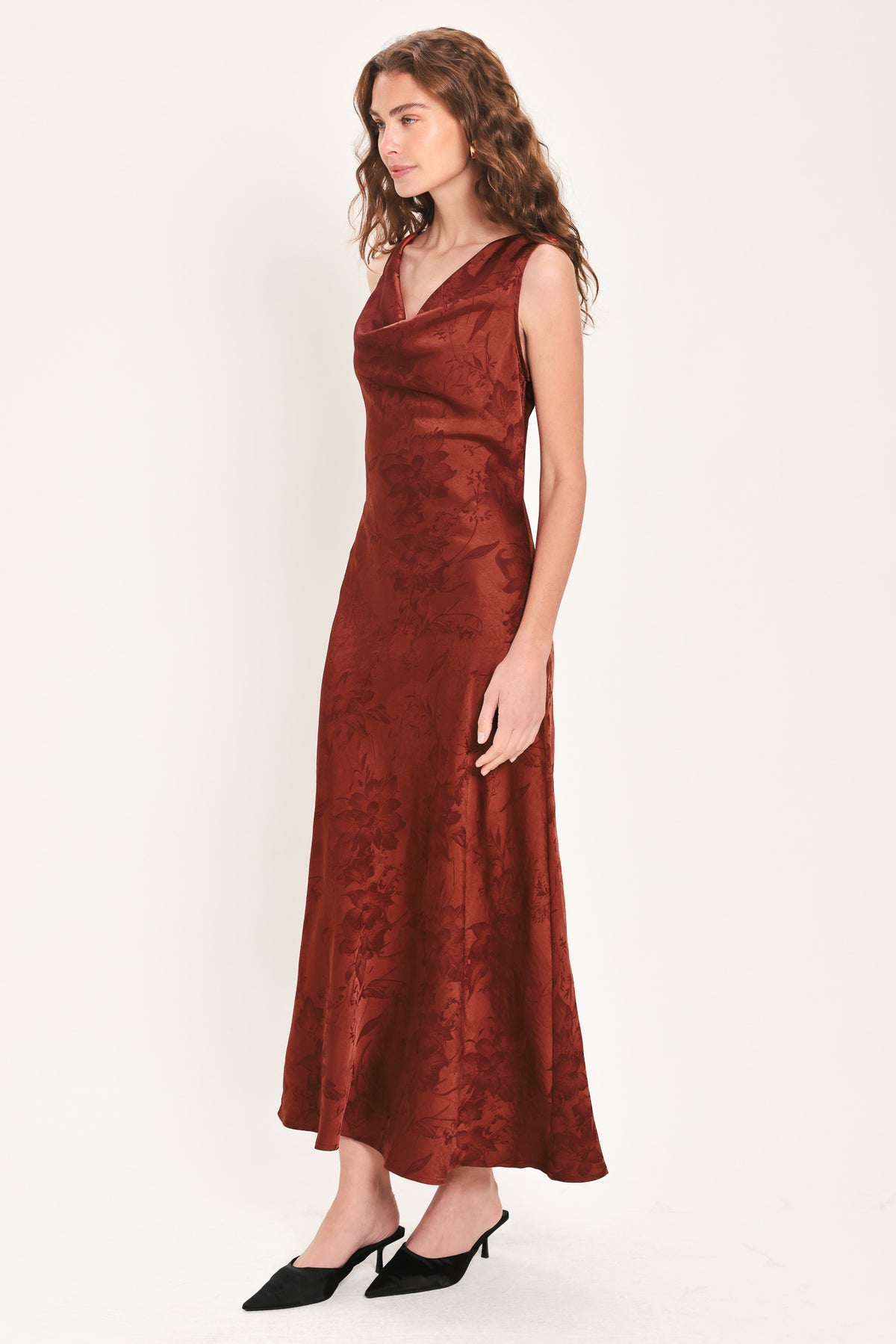 Woman wearing a sleeveless brick red satin jacquard midi dress with a cowl neckline and u-back | Flying Tomato