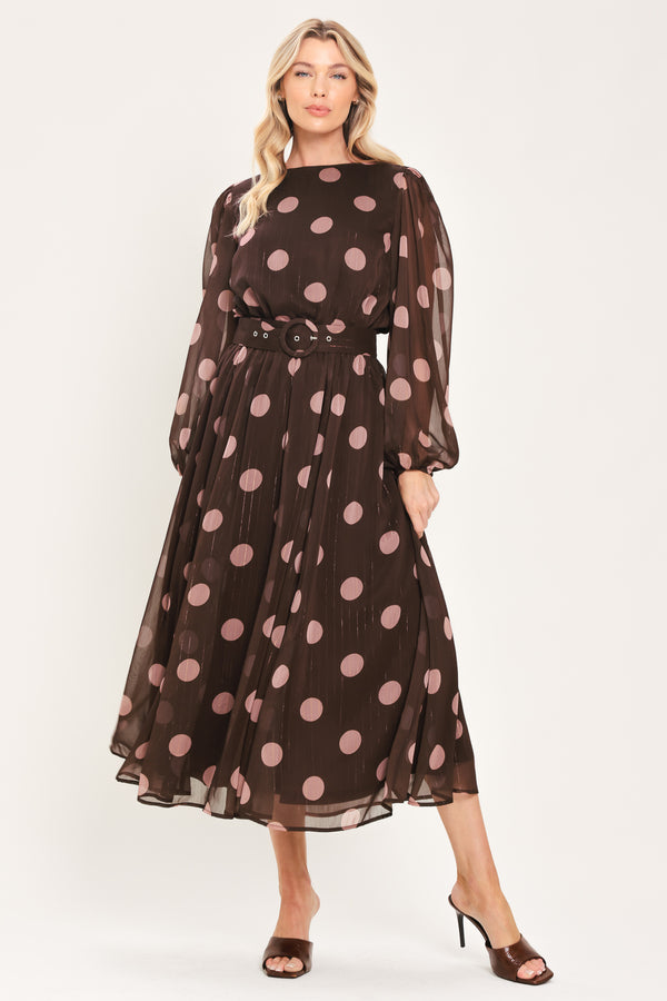 A woman modeling a brown midi dress with a pink polka dot pattern, long sheer sleeves, and a matching belt | Flying Tomato