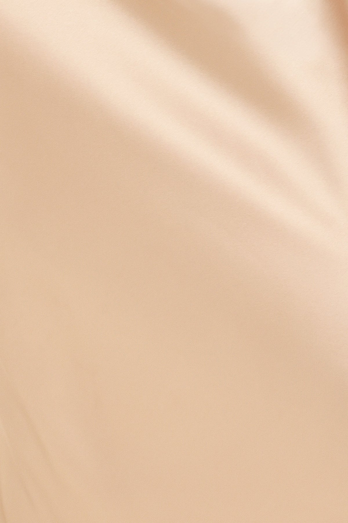 A woman modeling a floor-length, one-shoulder satin gown in a champagne beige color | Flying Tomato