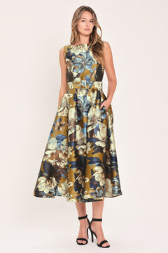 A woman modeling a sleeveless midi dress with a floral print in olive green, navy blue, beige, and white | Flying Tomato