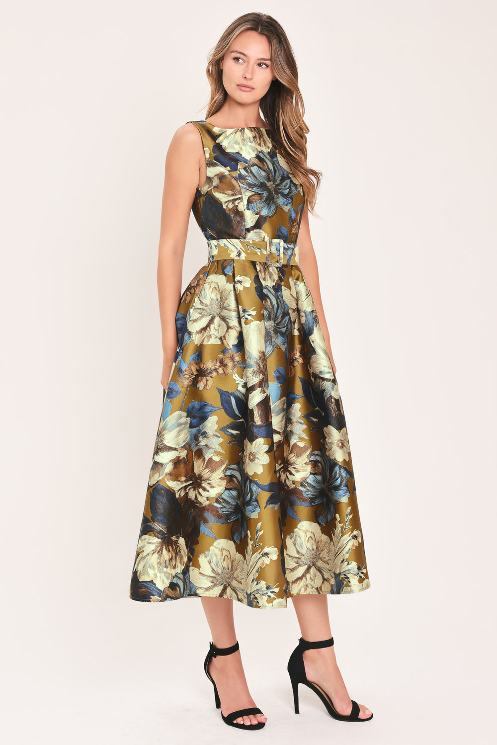 A woman modeling a sleeveless midi dress with a floral print in olive green, navy blue, beige, and white | Flying Tomato