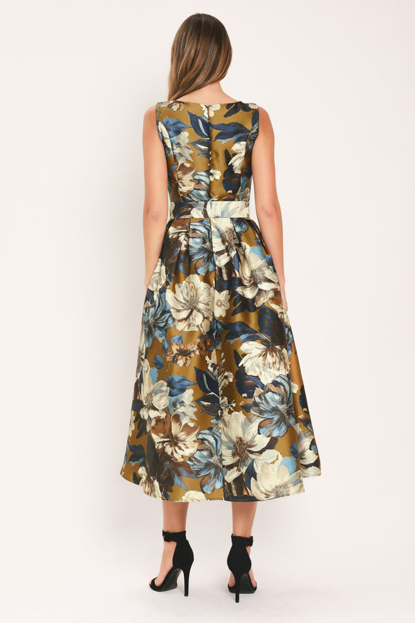 A woman modeling a sleeveless midi dress with a floral print in olive green, navy blue, beige, and white | Flying Tomato