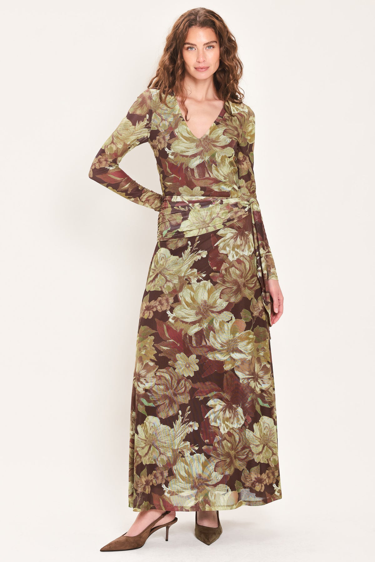 Woman wearing a dark maroon long sleeve mesh maxi dress with brown floral pattern and a waist tie belt that sits right above the hip | Flying Tomato