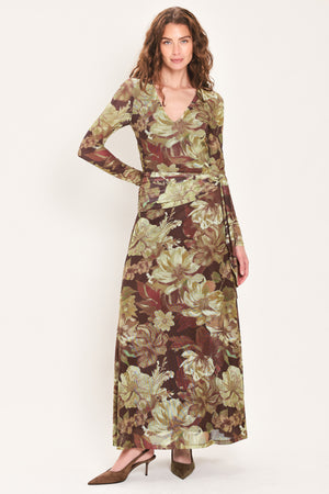 Woman wearing a dark maroon long sleeve mesh maxi dress with brown floral pattern and a waist tie belt that sits right above the hip | Flying Tomato