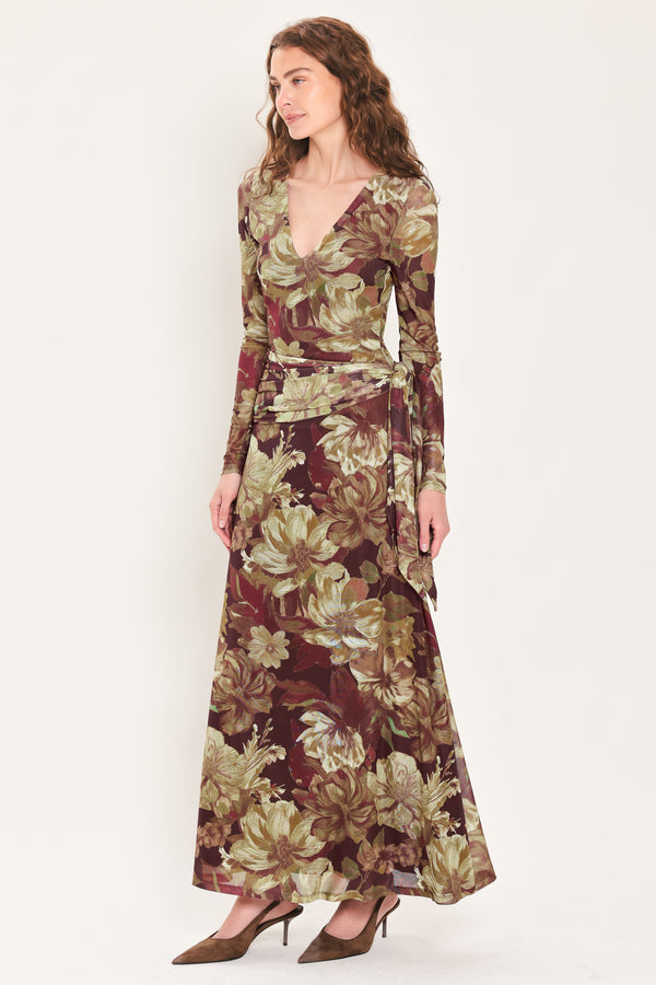 Woman wearing a dark maroon long sleeve mesh maxi dress with brown floral pattern and a waist tie belt that sits right above the hip | Flying Tomato