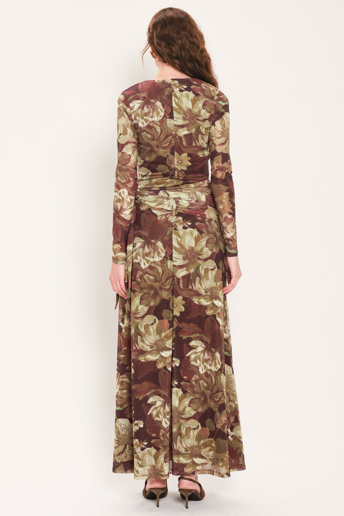 Woman wearing a dark maroon long sleeve mesh maxi dress with brown floral pattern and a waist tie belt that sits right above the hip | Flying Tomato