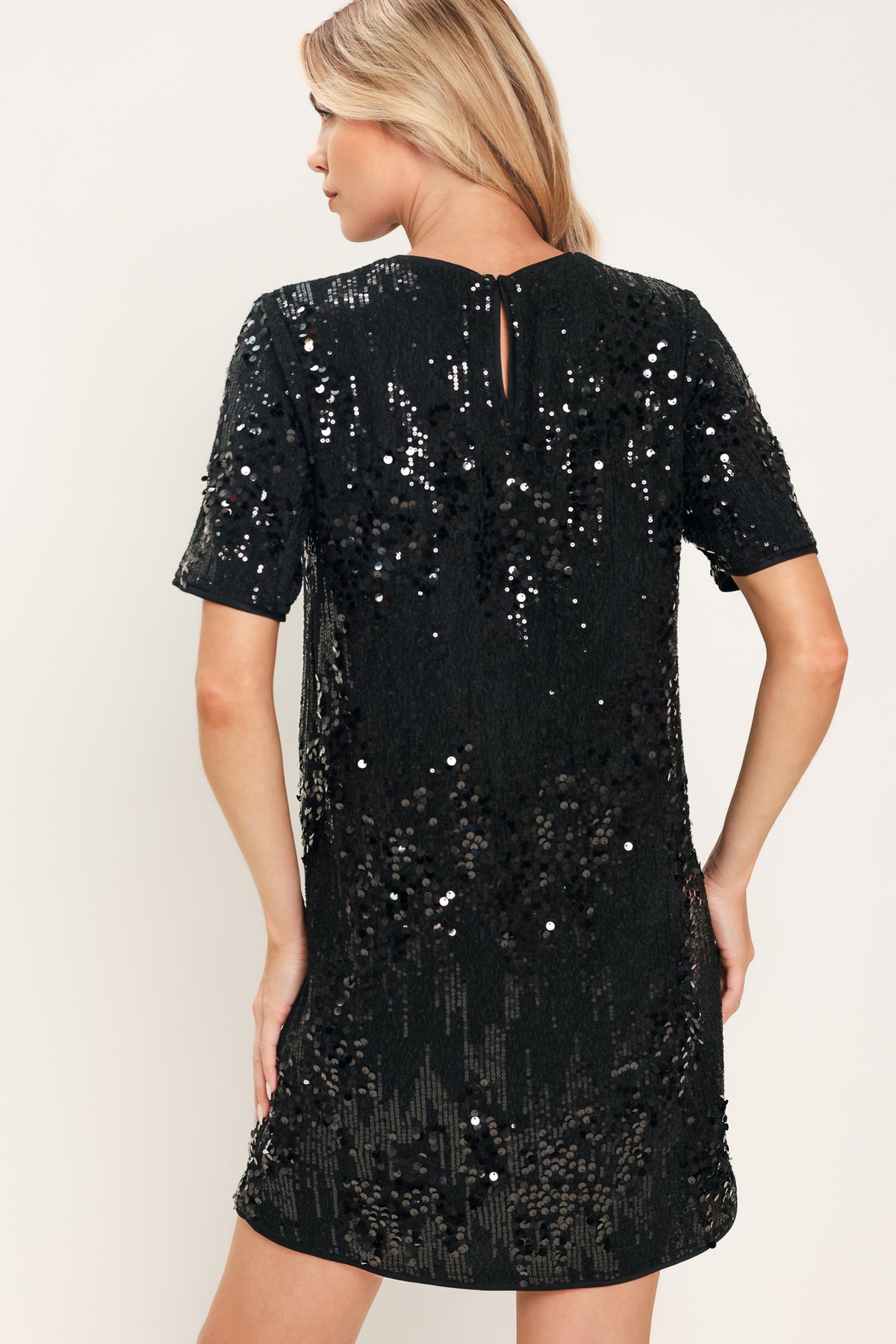 A woman modeling a short-sleeve black sequined mini dress | Flying Tomato