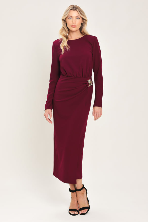 Woman wearing a long sleeve burgundy midi dress with a gold hardware holding slight gathered detailing around the hip | Flying Tomato