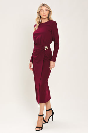 Woman wearing a long sleeve burgundy midi dress with a gold hardware holding slight gathered detailing around the hip | Flying Tomato